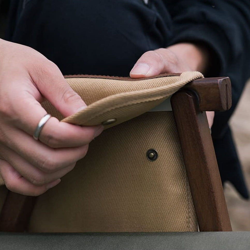Close-up of the snap attachment on the Setstead Camp Chair Side Pocket wrapped around a wooden camp chair arm
