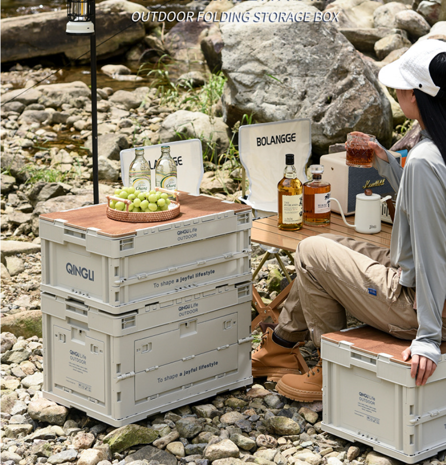 Stacked Setstead 65L Multifunction Storage Boxes beside a camp table at a rocky riverside campsite