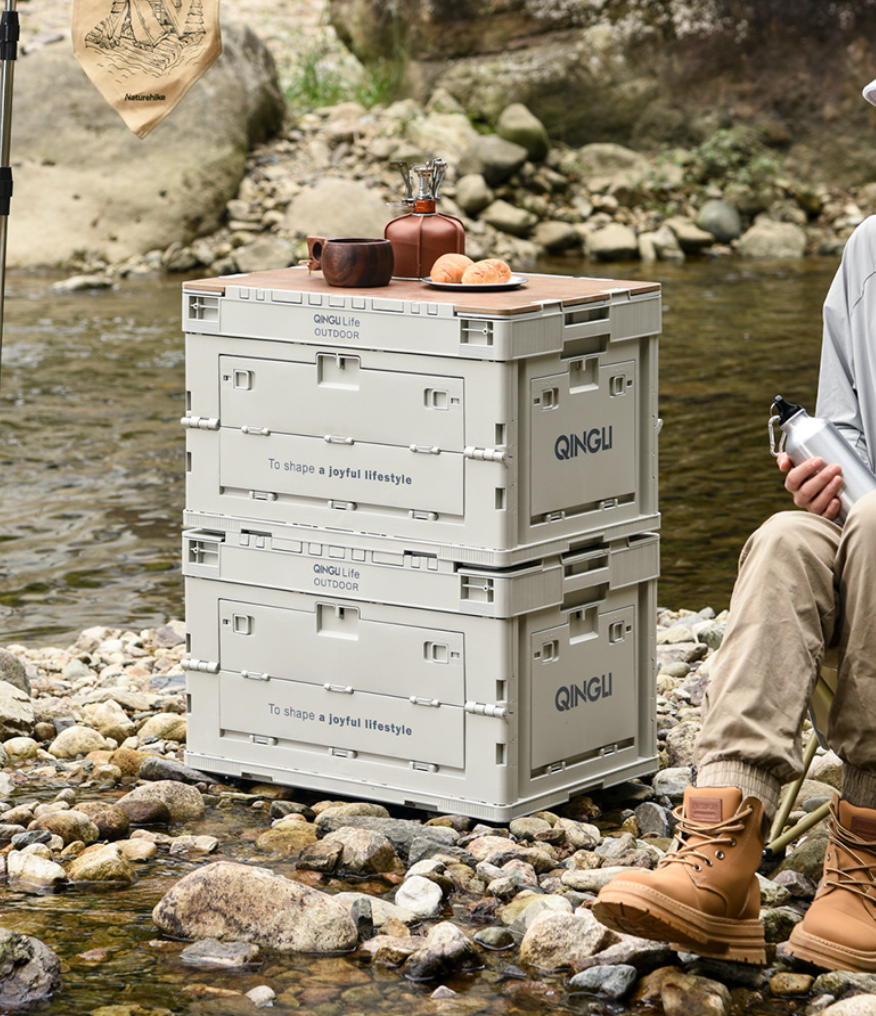 Two stacked Setstead 65L Multifunction Storage Boxes used as a side table at camp